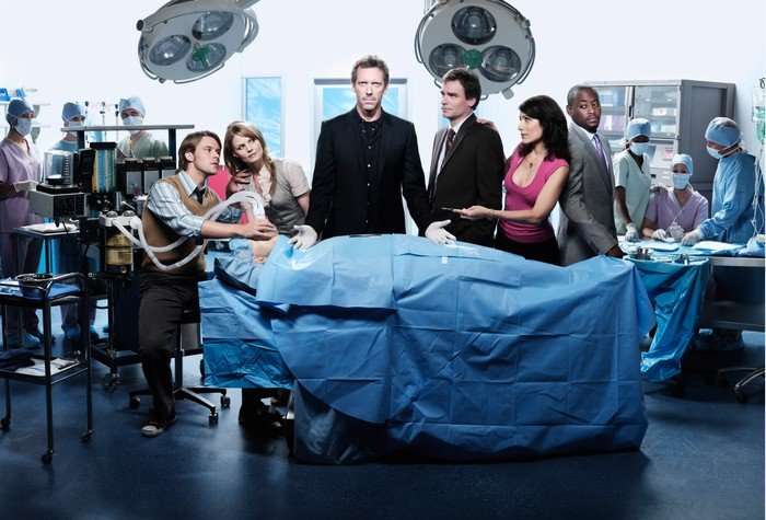 House - Season 4 Jesse Spencer as Dr. Robert Chase, Jennifer Morrison as Dr. Allison Cameron, Hugh Laurie as Dr. Gregory House, Robert Sean Leonard as Dr. James Wilson, Lisa Edelstein as Dr. Lisa Cuddy and Omar Epps as Dr. Eric Foreman in House M.D. They are stood behind a patient in a bed, under a blue sheet, in a hospital room.