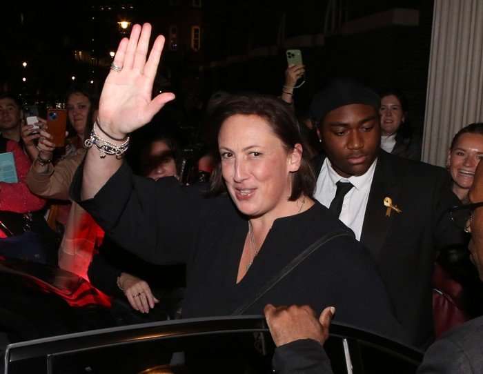 Miranda Hart walking into a car, smiling ahead as she waves.