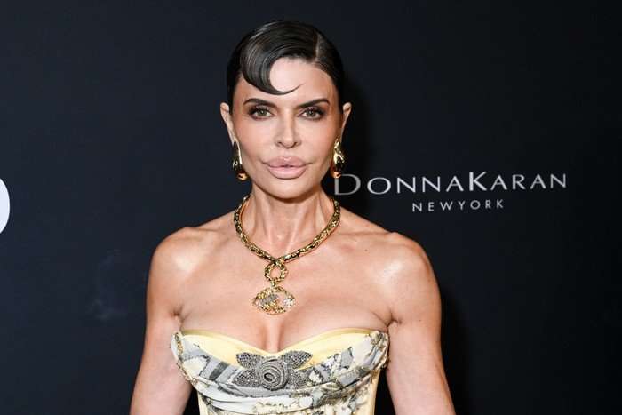 the-traitors-US Lisa Rinna looking ahead wearing a sleeveless gown and statement gold necklace.