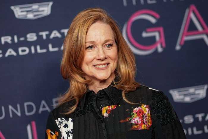 laura-linney-lanterns A close up of Laura Linney smiling ahead wearing a black patterned dress.