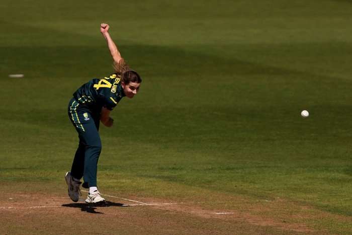 Annabel Sutherland Australia all-rounder Annabel Sutherland, in green and yellow kit, bowls a ball on the pitch in Cardiff.