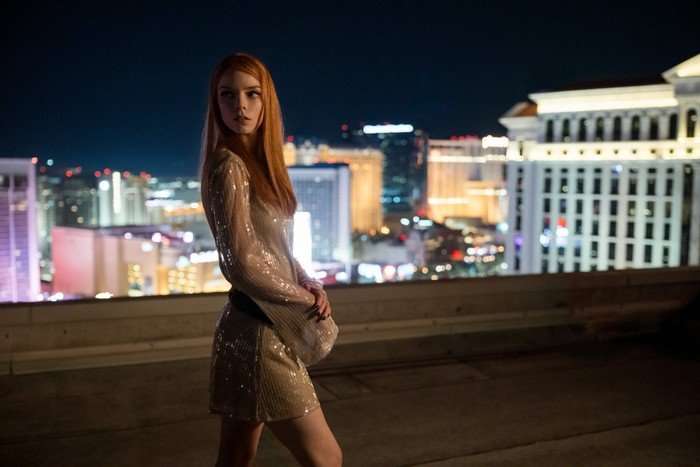 Anya Taylor Joy in Lucky, wearing a dress and stood on a rooftop in front of a city skyline.