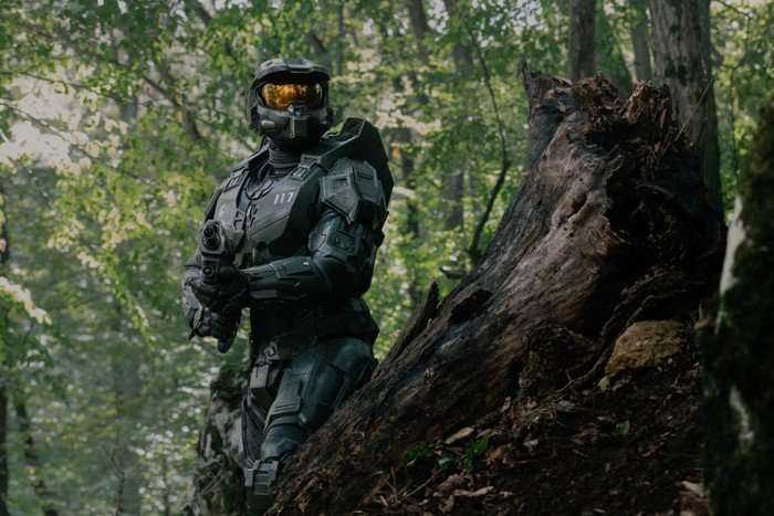 Pablo Schreiber Master Chief Halo Master Chief, Spartan John-117 in Halo season 2, wearing full armour and pointing his gun in a forest