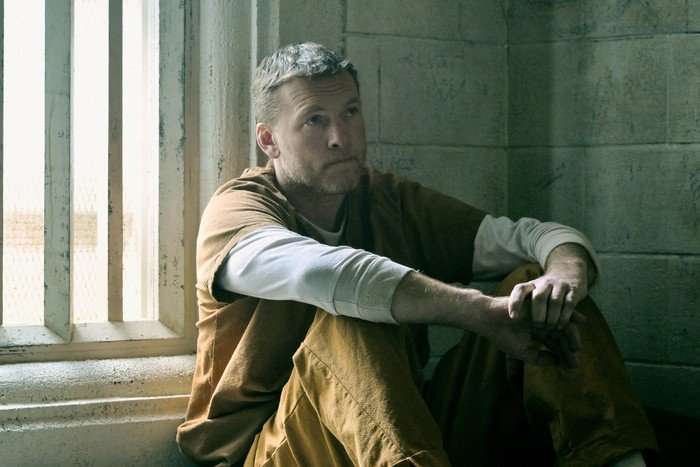Sam Worthington as David Burroughs in I Will Find You. A man in prison on his bed.