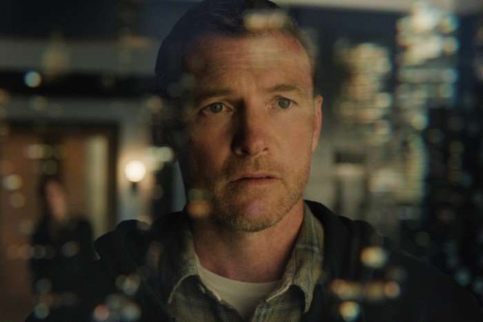 I_Will_Find_You_n_S1_E2_00_35_14_15_R Sam Worthington as David Burroughs in I Will Find You, looking through a window, distressed.