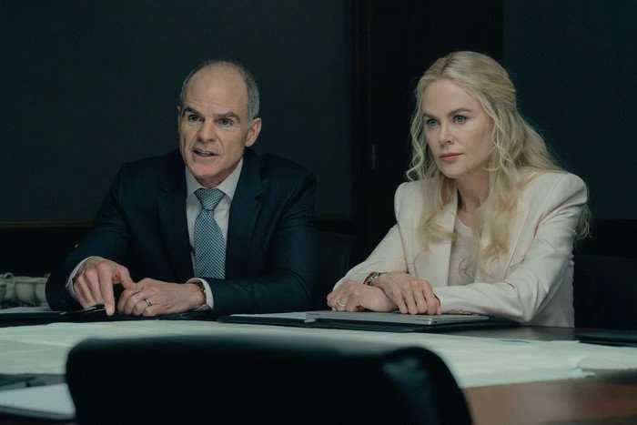 Lioness_305_RG_0202_0349_RT_f Nicole Kidman and Michael Kelly in Lioness, sat one side of a table, both wearing suits.
