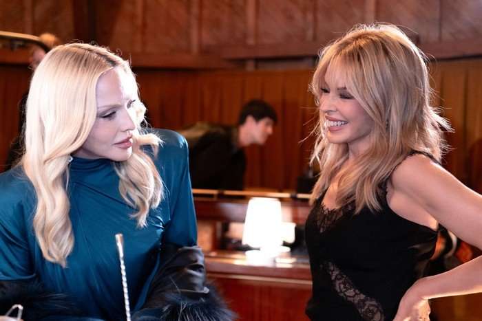 Kylie Minogue and Madonna speaking to one another.