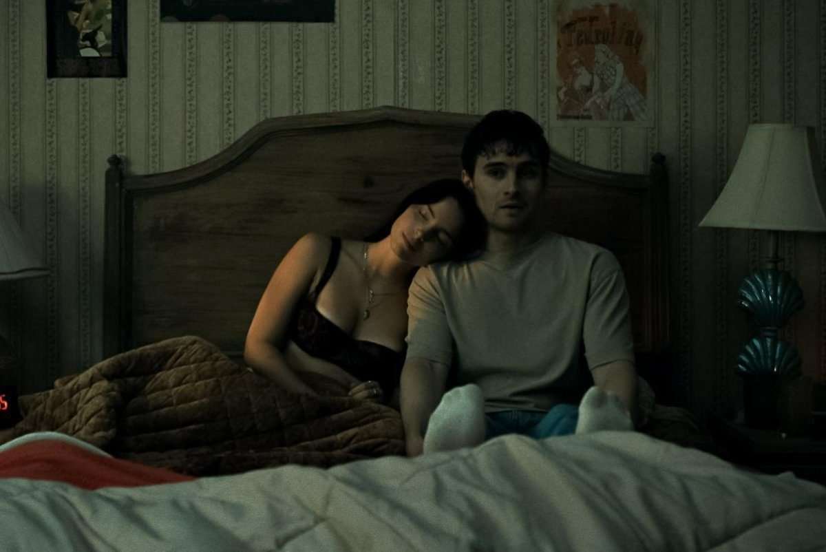 Nikki (Inde Navarette) and Bear (Michael Johnston) on a bed in the horror film, Obsession, written and directed by Curry Barker.