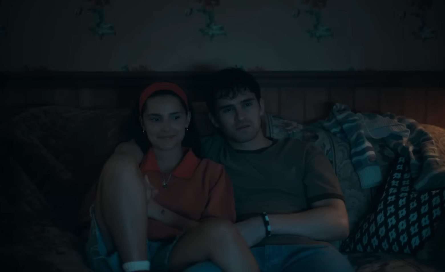 Nikki (Inde Navarrette) and Bear (Michael Johnston) sitting on a couch together in the horror film, Obsession.