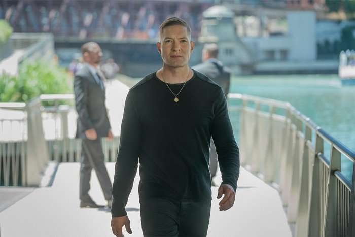 Joseph Sikora as Tommy Egan in Power Book IV: Force season 2 wearing a dark outfit, walking on a bridge