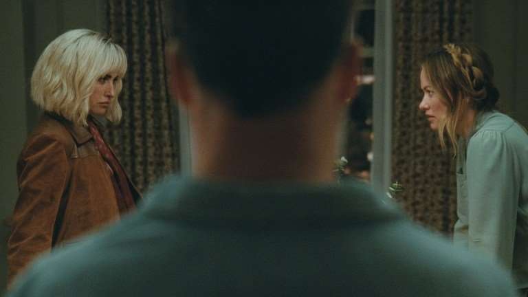 I&rsquo;m not going to begin by stating emphatically that Penelope Cruz and Edward Norton play sexy-time ghosts in Olivia Wilde&rsquo;s The Invite&hellip; but what if they might be ghosts, who happen to be sexy? I&rsquo;m joking, but also stay with me for a minute. Still high off its buzzy premiere at Sundance, The Invite walks, blurs, and utterly dissolves all manner of boundaries and bougie festival taboos. Floating with an ethereal mystique that borders on the occult, as well as a painfully hilarious naturalism, this is a movie that orbits around a marriage in midlife catastrophe to the point of dizziness&mdash;an even more impressive feat after the film was marketed with such deceptive seduction. To be sure, Cruz and Norton are quite appealing, the seemingly perfect couple upstairs in a posh, if ancient, New York City tenement building. They initiate friendly conversation in the elevator, look gorgeous while making preternatural eye contact with neighbors, and apparently have passionate, earth-shattering sex after midnight each evening. Angela and Joe (Wilde and Seth Rogen) should know. They hear it every night through their ceiling, along with a 12-year-old daughter who is never seen in the film. There is something just otherworldly about Pi&ntilde;a and Hawk (Cruz and Norton). And it leaves our central couple so alternatingly resentful and envious that the movie begins with an insert card of an Oscar Wilde quote: the eternal harbinger of doom for any romantic sentimentality beyond skin-deep nihilism. So when Joe and Angela invite Pi&ntilde;a and Hawk over for a couple&rsquo;s dinner, something aloof is in the air. Joe thinks it&rsquo;s tension, as he is more than ready, eager even, to complain about the animal sounds through the floorboards. But for our spirited guests, the tension could have an entirely different flavor, one of suspense as they are here to&mdash;eventually&mdash;propose the downstairs stuffed shirts join them in a shared sexual experience. They want to swing by switching spouses for the night. The ghostly element I mentioned earlier is a bit of a come-on, but not by much. While the film quotes Wilde, Oscar, there&rsquo;s more than a touch of Dickens and his descendants about the way Pi&ntilde;a and Hawk float into our unhappy protagonists&rsquo; lives. They&rsquo;re kinky Jacob Marleys, freaky Clarences, the angel of mercy in It&rsquo;s a Wonderful Life who&rsquo;s come to grant Jimmy Stewart a second chance at life after decades of disappointment by getting frisky in the kitchen. Even the audience is tempted into thinking they&rsquo;re watching one kind of beguiling sex comedy, which we kind of get, even as we&rsquo;re really being lured into a far more existential exploration of love and marriage after the romance has died. Are things not already in the Twilight Zone when an orgy invite from strangers amounts to the closest thing to high romance Joe or Angela&rsquo;s heard in years? The trick of Olivia Wilde&rsquo;s film and its inviting screenplay by Rashida Jones and Will McCormack is its structure. Based on the Spanish film The People Upstairs, Wilde&rsquo;s picture borrows the original&rsquo;s real-time setting of an unwieldy night of collapsing inhibitions and glasses of wine giving way to low-lit confessions in a cozy apartment&rsquo;s corners. Among Jones and McCormack&rsquo;s many scripted innovations, however, is the sensation that this is occurring in a bit of a theater workshop. This isn&rsquo;t a knock at the performances, which are excellent, but at the sense we are sitting with a group of professionals, also over wine, as they psychoanalyze and deconstruct a messy, impermanent thing: the marriage of two people who care for each other but lost love a long time ago. Wilde shoots the film almost wholly in steadicam and in an underlit setting wherein the decorative paint colors and apartment accoutrements that Angela distracts herself with are indistinguishable. She isn&rsquo;t wrong to note Joe is checked out when she talks about &ldquo;finishing&rdquo; the bedroom several years on, but Wilde the filmmaker cannot let her character hide behind minutiae. She drowns Angela and Joe&rsquo;s faux domesticity into an inviting yet gloomy shadow world. Similarly, the helmer constantly films Rogen&rsquo;s Joe as a domineering force in the life of his wife, towering over the frame and shot in harsh low light like a Halloween fright mask. At other times, the pair are caught in line of sight of each other in their horseshoe-shaped apartment, with the duo able to simply look up across the way and see one another in parallel windows. Yet they never do. It would make eye contact and break the spell of mutually agreed upon isolation. At its core, though, one does not cast a talent like Rogen, or for that matter Wilde at her most mischievous, and not revel in the humor. Rogen accentuates a new note of tired resignation to his likable, schlubby everyman persona, but there&rsquo;s a lot more bitterness to Joe than Matt Remick in The Studio, as well as more pathos. This is a sad sack too self-involved to recognize he&rsquo;s dragging his marriage down, but his unhappiness is not unsympathetic to anyone who reached a certain point in life where they realized they did not become the person they dreamed about when they were 20. It also makes his acerbic digs at Pi&ntilde;a and Hawk, particularly for the latter&rsquo;s clearly self-chosen name, all the more biting. Meanwhile Cruz delights in her role that purposefully walks a line between the ethereal and earthy. For much of the film, she might be a cipher, or certainly a projection of Joe and even Angela&rsquo;s desires, albeit in very different contexts, but Cruz plays it with a rueful self-awareness. She&rsquo;s the cat plucking at a pair of wounded canaries&rsquo; wings. The scene where she specifically attempts to uncoil Joe out of his wound-up funk to Sade&rsquo;s now 26-year-old(!) &ldquo;By Your Side&rdquo; is a harmonious car crash; a collision of sweetness and cringe, reverie and gallows humor despair. And I haven&rsquo;t even mentioned his &ldquo;dance&rdquo; moves. The Invite is a shimmering dramedy for adults of a certain age, and perhaps a sobering epiphany that this can now be so acutely tailored to elder Millennials and younger Gen-Xers at that. The film is genuinely sexy but in the awkward and disarming way of clumsy foreplay. It stumbles and stammers, with its proverbial pants caught around the ankles before the whole thing tonally keels over. Yet for all the screenplay&rsquo;s verbose intellectualization about sensuality, and Wilde&rsquo;s obvious preoccupation with it as a storyteller, the main event is something more intimate and unspoken. It&rsquo;s a lament about the passage of time, milestones left discarded, and maybe even marriages that also have outlived their shelflife. One might even call it haunting, complete with the mysterious good-looking specters descending from above. Penelope Cruz and Olivia Wilde in The Invite Review