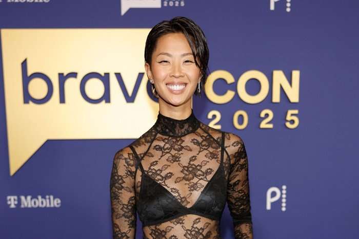 the-traitors-US Kristen Kish stood wearing a black lace top and smiling ahead.