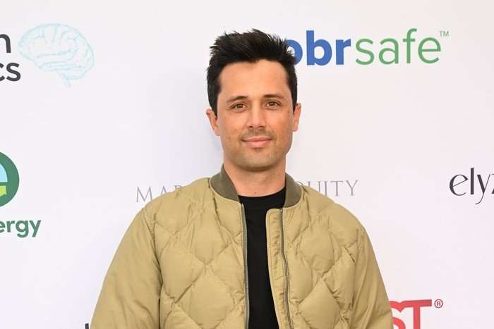 the-traitors-US Stephen Colletti wearing a beige quilted jacket and smiling ahead.