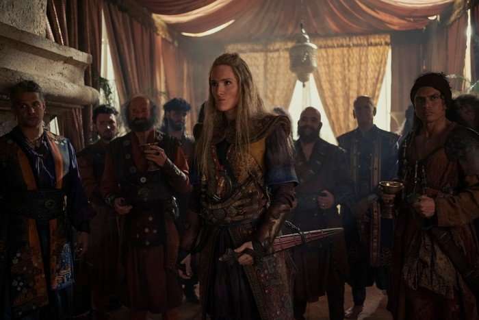 abigail-thorn Abigail Thorn as Admiral Lohar in House of the Dragon stands in a crowded tent structure.