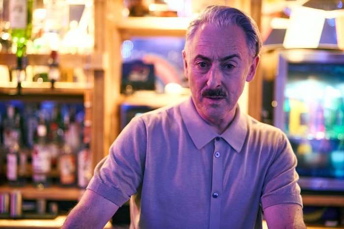alan-cumming-leo-tip-toe Alan Cumming as Leo in Tip Toe. He is stood behind the bar at his club, with a stern expression on his face