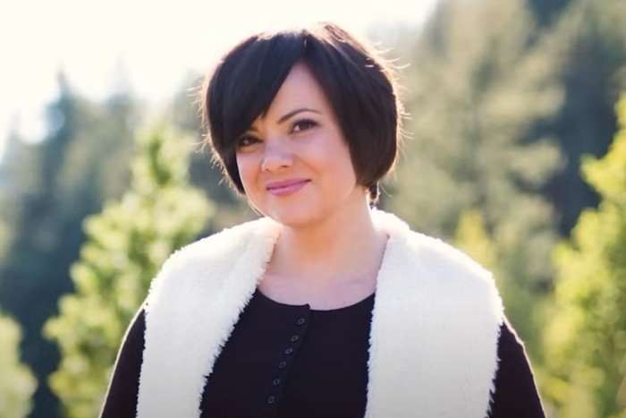 amanda-riley (1) A woman wearing a black t-shirt and white gilet. She has short brown hair and is smiling.