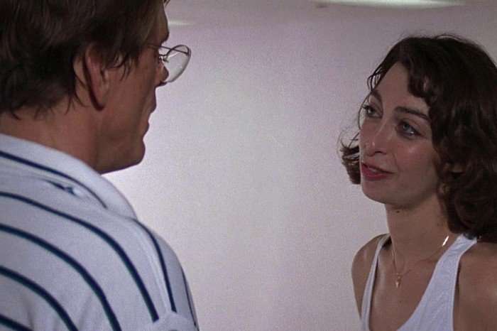 cape-fear-lori-davis Illeana Douglas as Lori Davis with short dark curly hair smiles up at a bespectacled Nick Nolte as Sam Bowden wearing a striped polo shirt in a softly lit scene from Cape Fear (1991).
