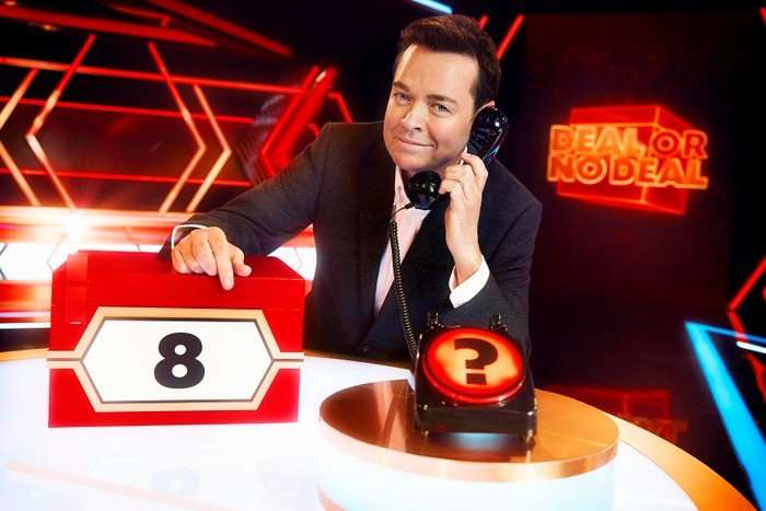 Stephen Mulhern Deal or No Deal Stephen Mulhern for Deal or No Deal, holding a black phone and leaning on a red box