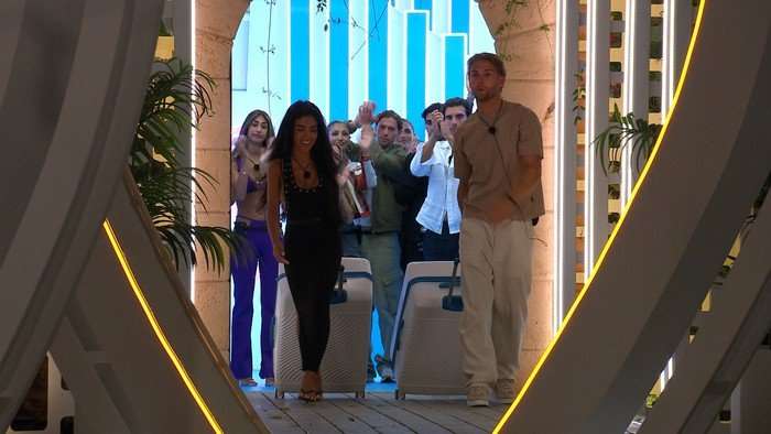 Love Island S13 Tina and Tommy walking out of the villa with their suitcases as the Islanders wave them off.
