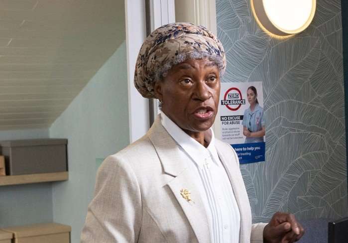 Flo Wilson as Claudette Anderson in a blazer in the doctor's surgery in Emmerdale.