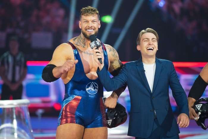Giant and Barney Walsh. Barney is holding a microphone and is laughing while Giant is smiling