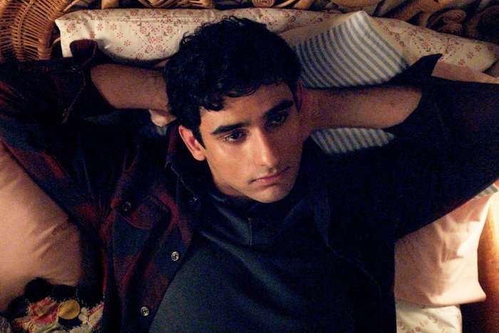 A Good Girl's Guide To Murder Ravi lying on his bed with his hands placed behind his head.