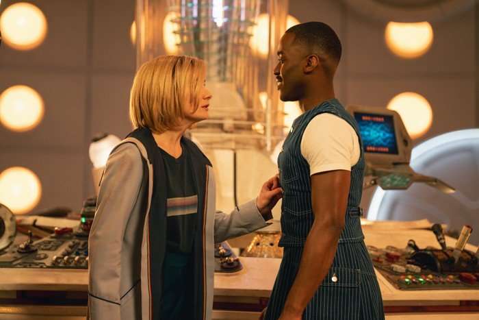 Jodie Whittaker as the Doctor and Ncuti Gatwa as the Doctor standing in the TARDIS and looking at each other, with Thirteen's hand gently on Fifteen's chest.