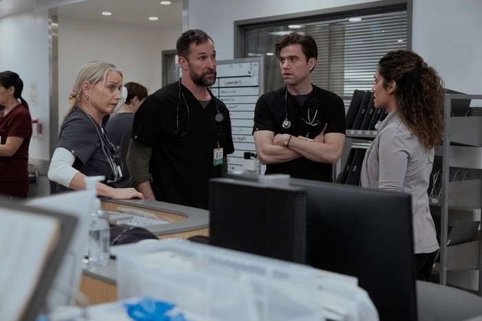Katherine LaNasa, Noah Wyle, Patrick Ball and Sepideh Moafi in The Pitt, stood together talking in a hospital.