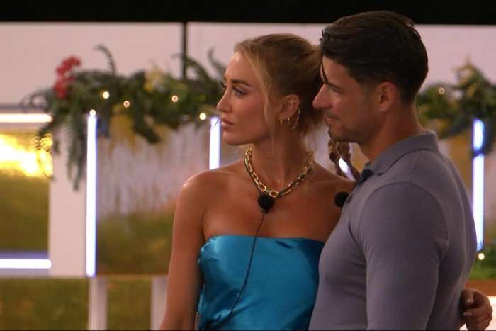 ©ITV Georgia Harrison and Anton Danyluk stood arm in arm as they look ahead at something.
