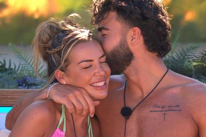 love-island (11) One person with their arm round another, kissing the side of their head.