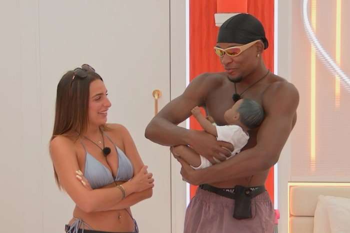 love-island - 2025-08-04T221614.568 Toni and Cach stood next toe ach other, smiling as Cach holds a toy doll.