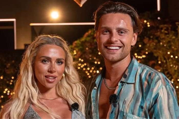 love-island (3) Gabby Allen and Casey O'Gorman stood next to each other, smiling ahead under an archway shaped like a heart.