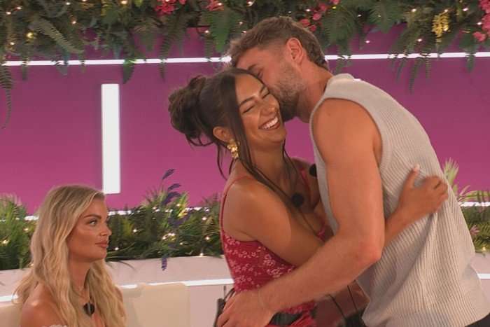 love-island (54) Helena sat down round the Love Island fire pit looking straight ahead as Shakira and Harry share a warm embrace.