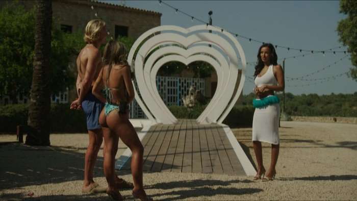 Yasmin and George stood opposite Maya Jama who is stood on the other side of the heart arch outside the villa.