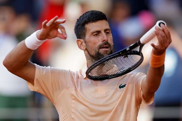 Novak Djokovic at French Open 2026 Novak Djokovic on court at the French Open pretending to play his tennis racket like a violin.