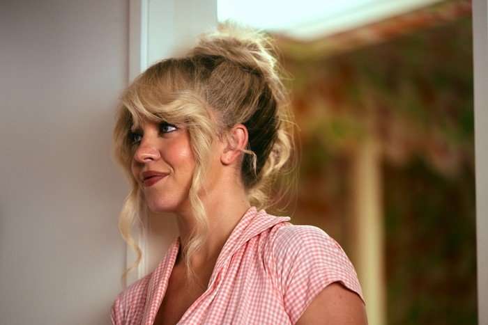Sydney Sweeney as Cassie Howard in a pink blouse stands in a doorway with her hair up in the Euphoria season 3 finale.