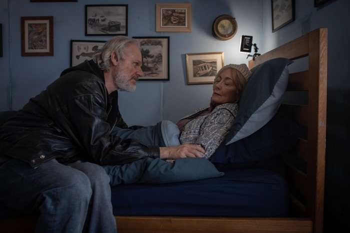 The Fortune Trevor Fox leaning over Paula Wilcox who is sat up sick in a bed.