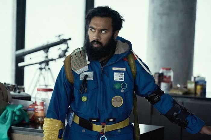 Himesh Patel as Jeevan Chaudhary in Station Eleven Himesh Patel as Jeevan Chaudhary in Station Eleven. He's wearing a blue jacket and is looking solemn.