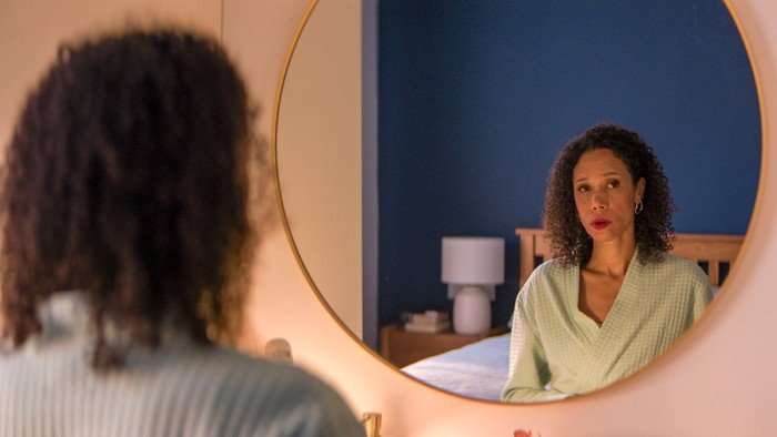 571864,TITLE:TIME - Series 3 Vinette Robinson plays Erica Bailey in Time season 3; she is sat in her bedroom, looking into a mirror with a straight face