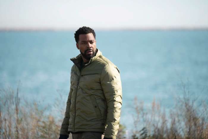 Chicago P.D. - Season 13 LaRoyce Hawkins as Officer Kevin Atwater in Chicago PD season 13; the character is stood in a coat on a grassy surface, with a large body of water in the background behind him
