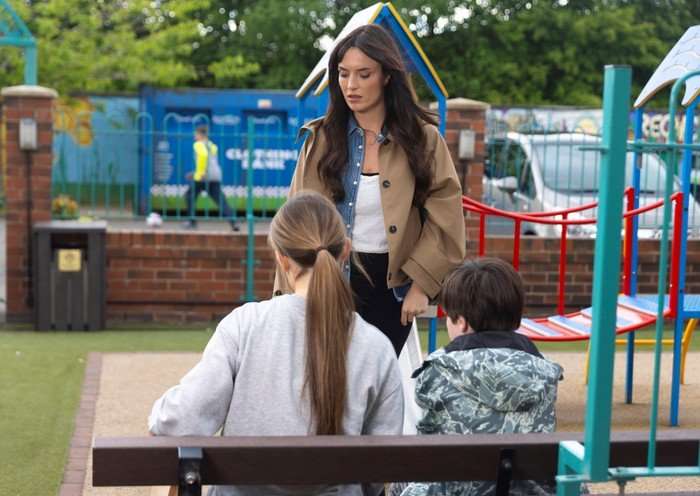 29_07_coro_jodie_lily_01 Jodie stands over Harry and Lily in the park in Corrie