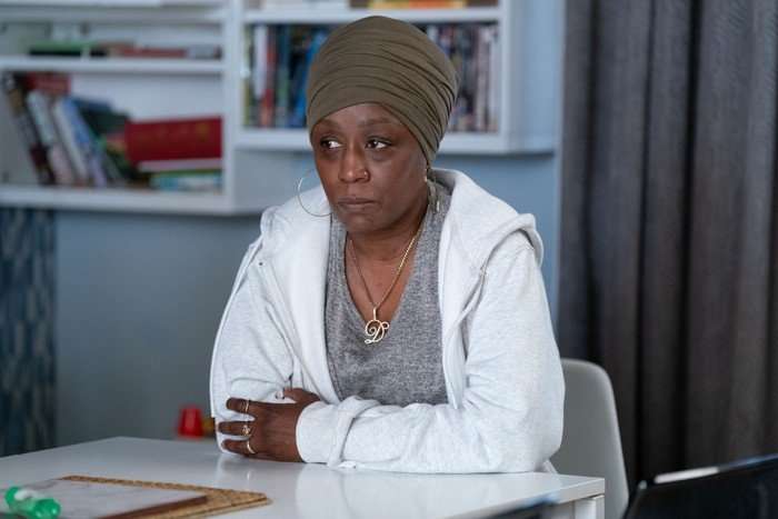 566671,TITLE:Eastenders Denise wearing a green head wrap and a white hoody in a scene from EastEnders