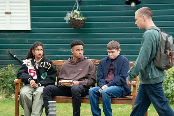 566706,TITLE:Eastenders Joel stands over Avani, Denzel and Barney in a scene from EastEnders