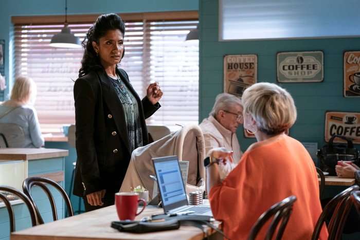 568585,TITLE:Eastenders Suki stands over Nicola, who is working on her laptop in the caff, in a scene from EastEnders