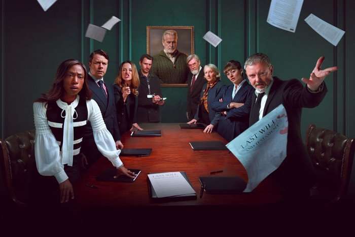 An image promoting TV drama I, Jack Wright. A group of people stand around a red table all looking at the camera. A portrait hangs on the wall behind them, and sheets of paper swirl around the room - one says, "The last will..."
