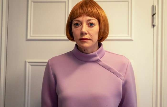 Diane Morgan as Linda in Ann Droid, wearing a pink top and stood by a door.