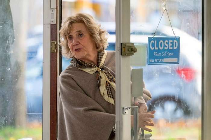 Margot Leicester as Phyllis in Ann Droid, stood in a shop doorway.