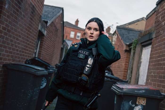 Katherine Devlin as Annie Conlon in Blue Lights, wearing a police uniform, stood in a street and looking shocked.