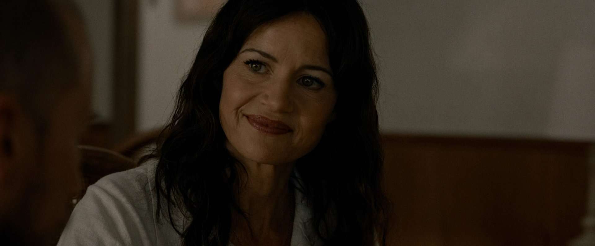 Carla Gugino smiling in the horror film, Lockbox