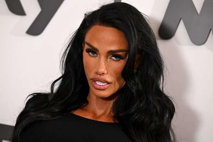 Katie Price posing against a white backdrop.